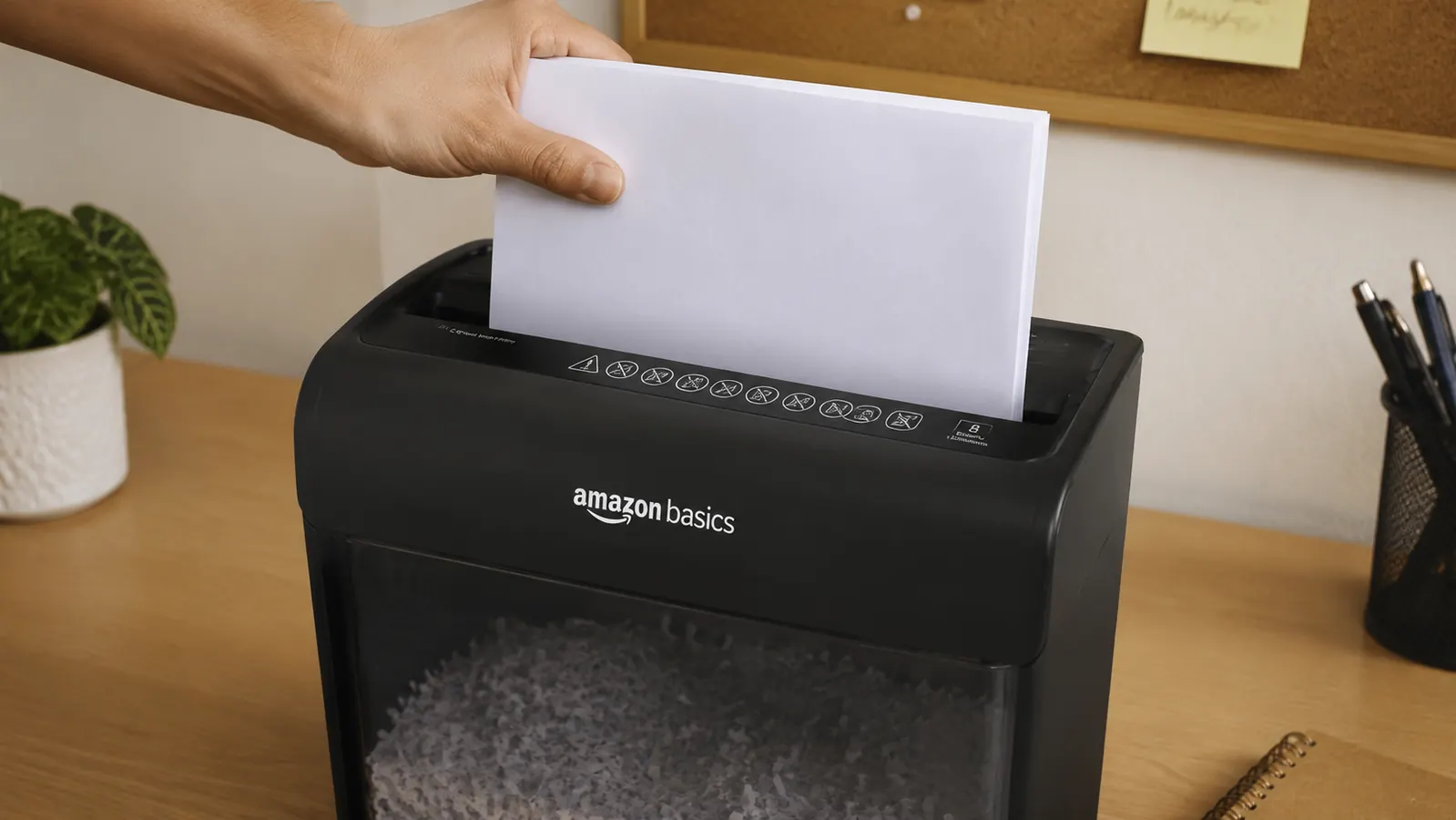 Hand feeding a few sheets of paper into the Amazon Basics cross-cut shredder feed slot